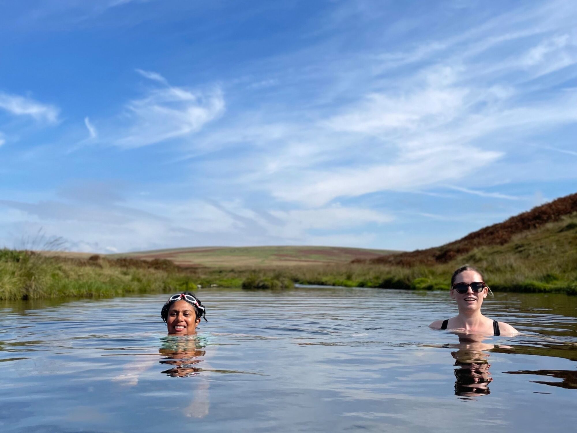 Two women  swimming in a river on Dartmoor during a Department of Wellbeing Retreat